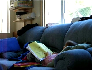 Peo reading a book on the couch.