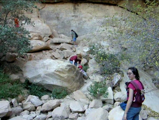 Peo climbing boulders.