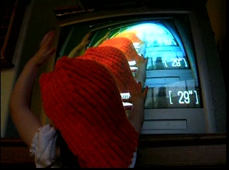 Peo with an orange wig in front of the TV.