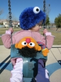 Blue Fuzzy Monster Who Likes Baked Goods Hat - Side, on swing